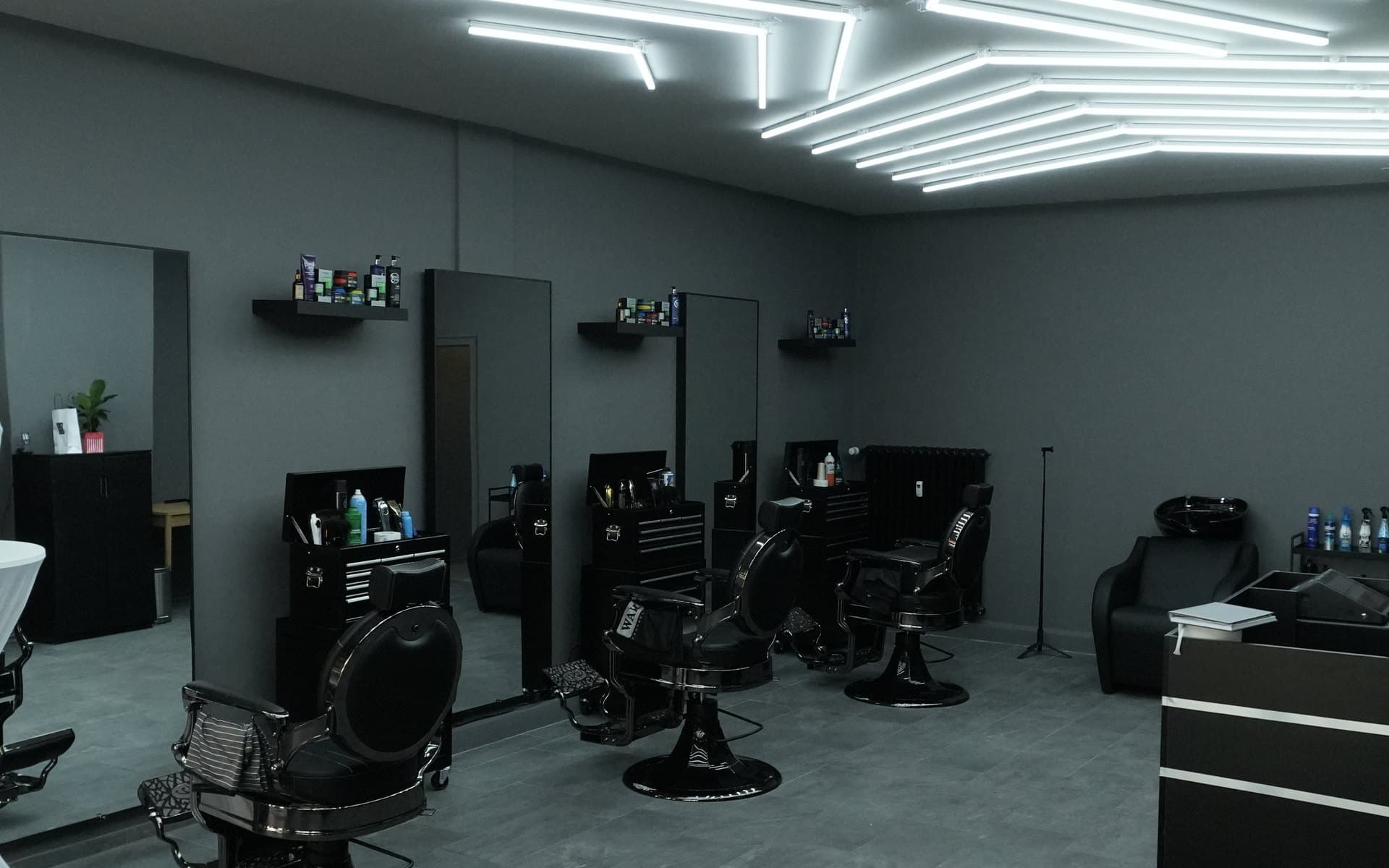 Innenraum von ShaYo Barbershop in Kiel: drei Barberstühle vor Spiegeln, Waschplatz und die Lichtdecke